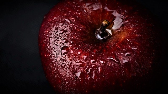 Ein Apfel, der mit Wassertropfen übersät ist